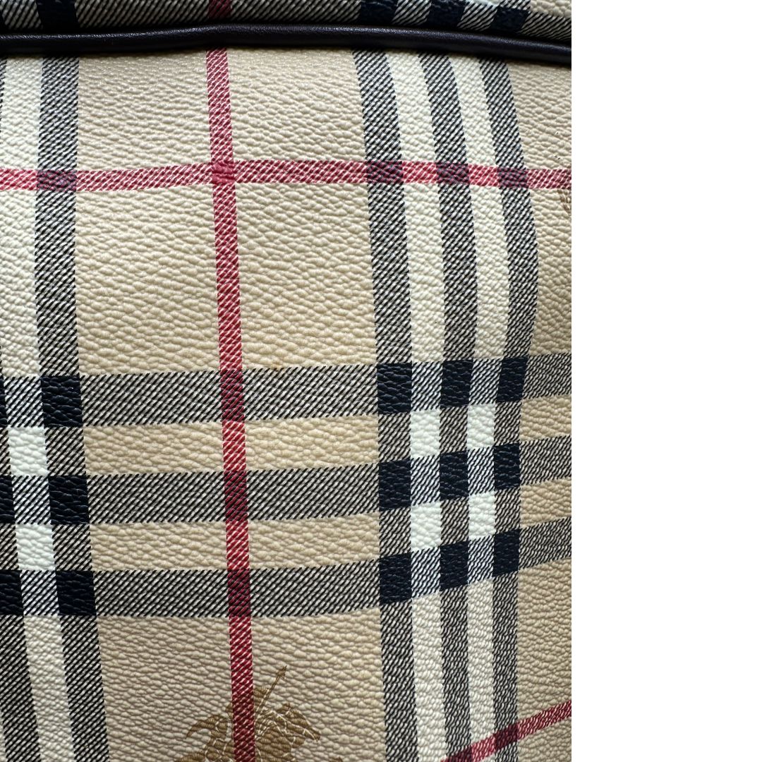 Alone sul canvas di un borsone Burberry in canvas trama tartan con finiture in pelle marrone testa di moro e parti metalliche dorate; munito di doppi manici stondati e una tracolla amovibile e regolabile.