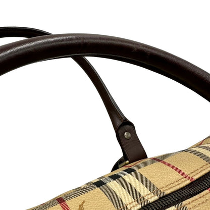 Manici di un borsone Burberry in canvas trama tartan con finiture in pelle marrone testa di moro e parti metalliche dorate; munito di doppi manici stondati e una tracolla amovibile e regolabile.