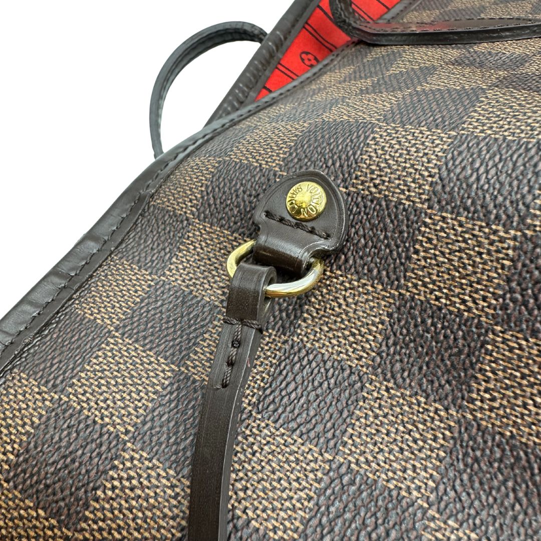 Parti metalliche di una borsa Louis Vuitton Neverfull GM in canvas Damier Ébène con finiture in pelle marroni testa di moro e parti metalliche dorate; munita di doppi manici, indossabile a spalla.