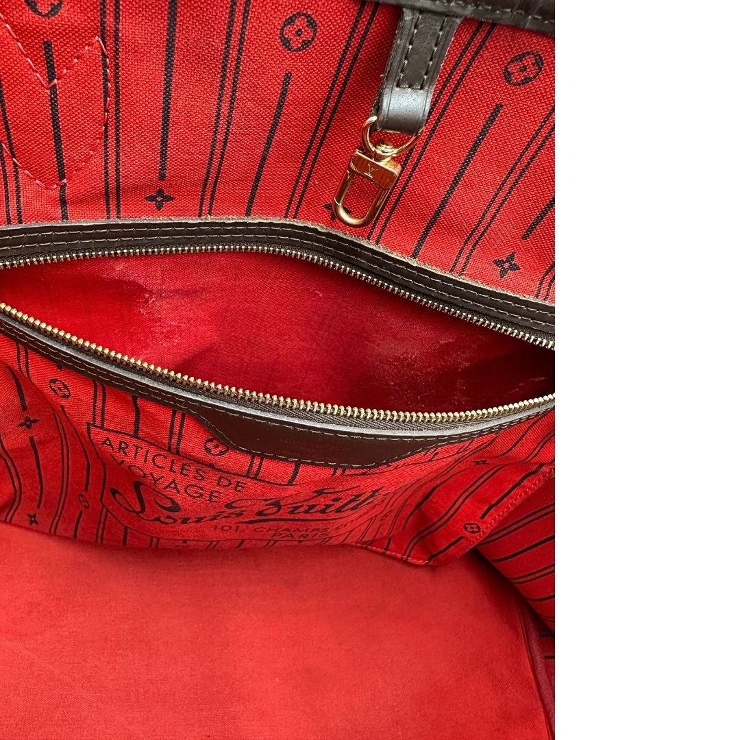 Taschino interno di una borsa Louis Vuitton Neverfull GM in canvas Damier Ébène con finiture in pelle marroni testa di moro e parti metalliche dorate; munita di doppi manici, indossabile a spalla.