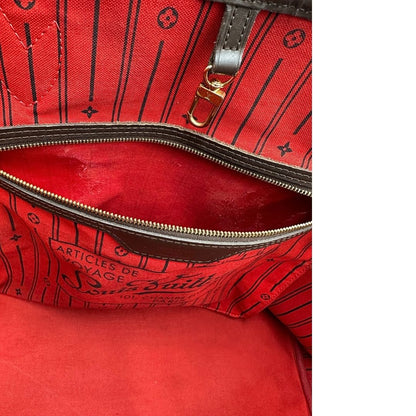 Taschino interno di una borsa Louis Vuitton Neverfull GM in canvas Damier Ébène con finiture in pelle marroni testa di moro e parti metalliche dorate; munita di doppi manici, indossabile a spalla.