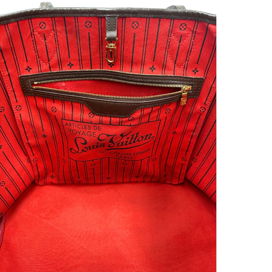 Interno di una borsa Louis Vuitton Neverfull GM in canvas Damier Ébène con finiture in pelle marroni testa di moro e parti metalliche dorate; munita di doppi manici, indossabile a spalla.