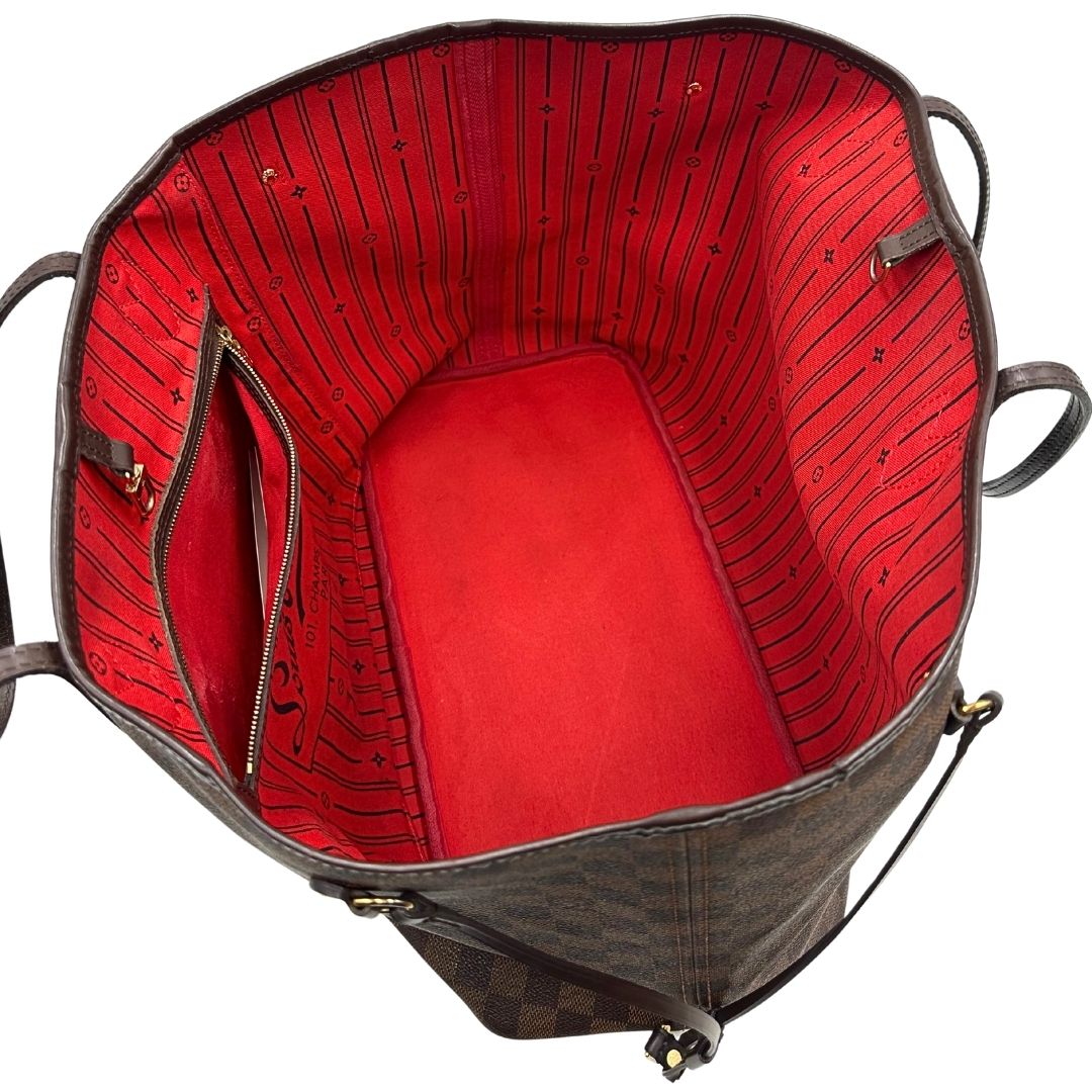 Interno di una borsa Louis Vuitton Neverfull GM in canvas Damier Ébène con finiture in pelle marroni testa di moro e parti metalliche dorate; munita di doppi manici, indossabile a spalla.