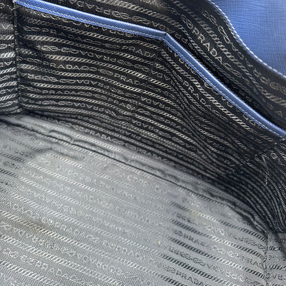 interno  della Borsa Prada in pelle saffiano blu con parti metalliche dorate; munita di doppi manici stondati e impreziosita da una clochette portachiavi, di lusso, originale, ottime condizioni, usata.