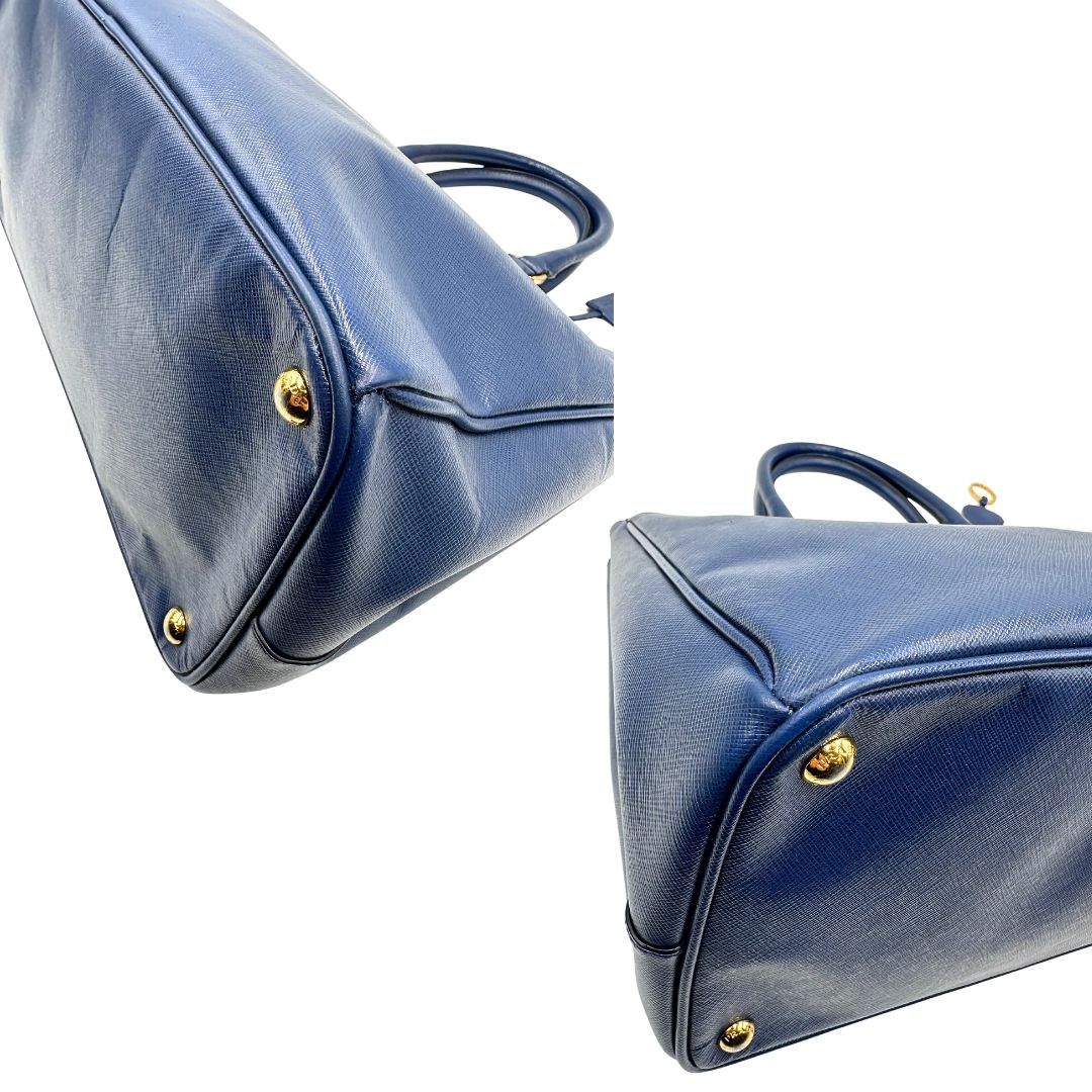 angoli  della Borsa Prada in pelle saffiano blu con parti metalliche dorate; munita di doppi manici stondati e impreziosita da una clochette portachiavi, di lusso, originale, ottime condizioni, usata. 