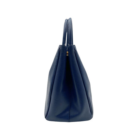 laterale della Borsa Prada in pelle saffiano blu con parti metalliche dorate; munita di doppi manici stondati e impreziosita da una clochette portachiavi, di lusso, originale, ottime condizioni, usata.