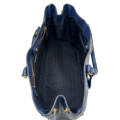 interno della Borsa Prada in pelle saffiano blu con parti metalliche dorate; munita di doppi manici stondati e impreziosita da una clochette portachiavi, di lusso, originale, ottime condizioni, usata.