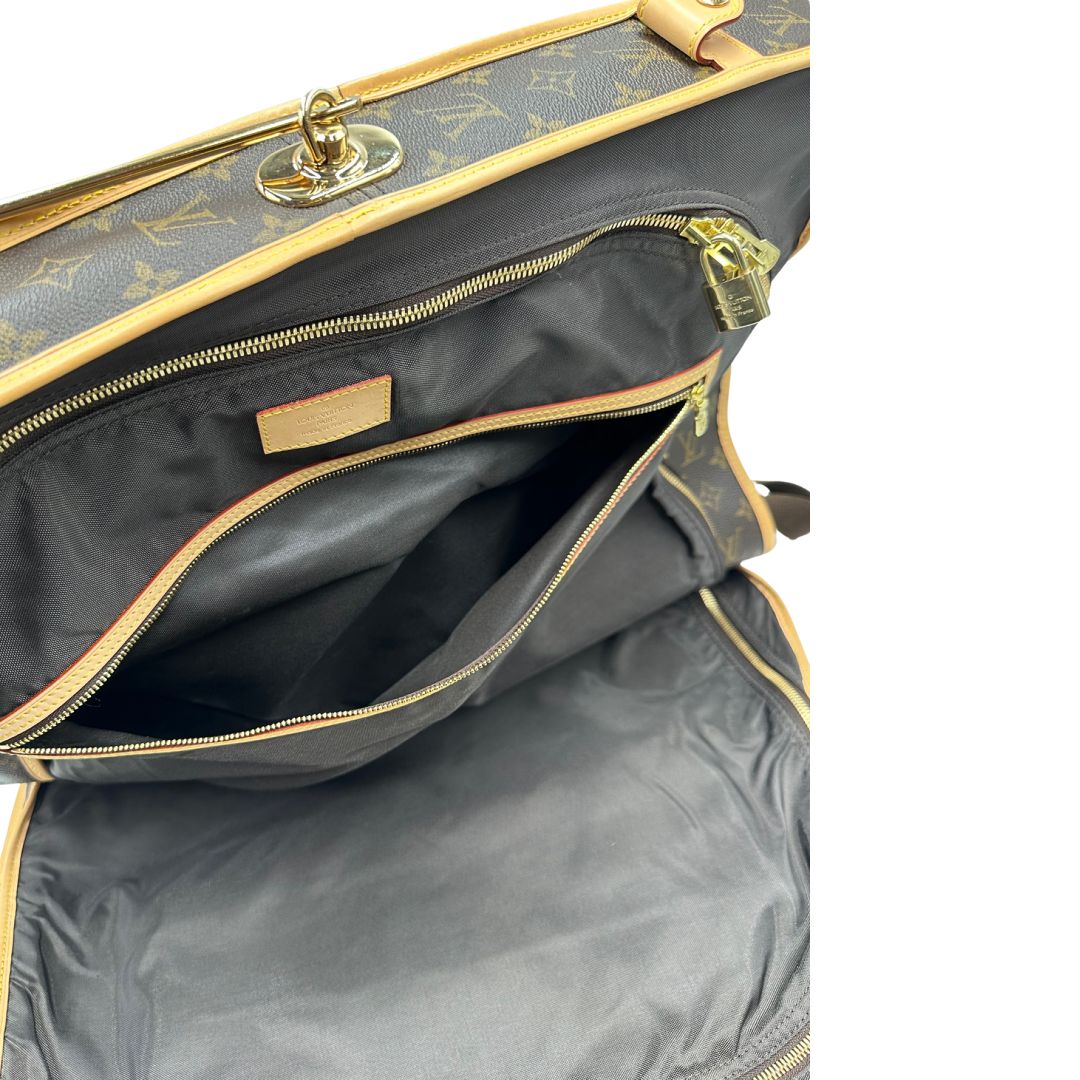 Interno di una Borsa da viaggio porta abiti in canvas marrone monogram con finiture in vacchetta naturale e parti metalliche dorate; munita di un manico singolo, una tracolla amovibile e regolabile e 2 grucce. Completa di Lucchetti e una chiave, dustbag.