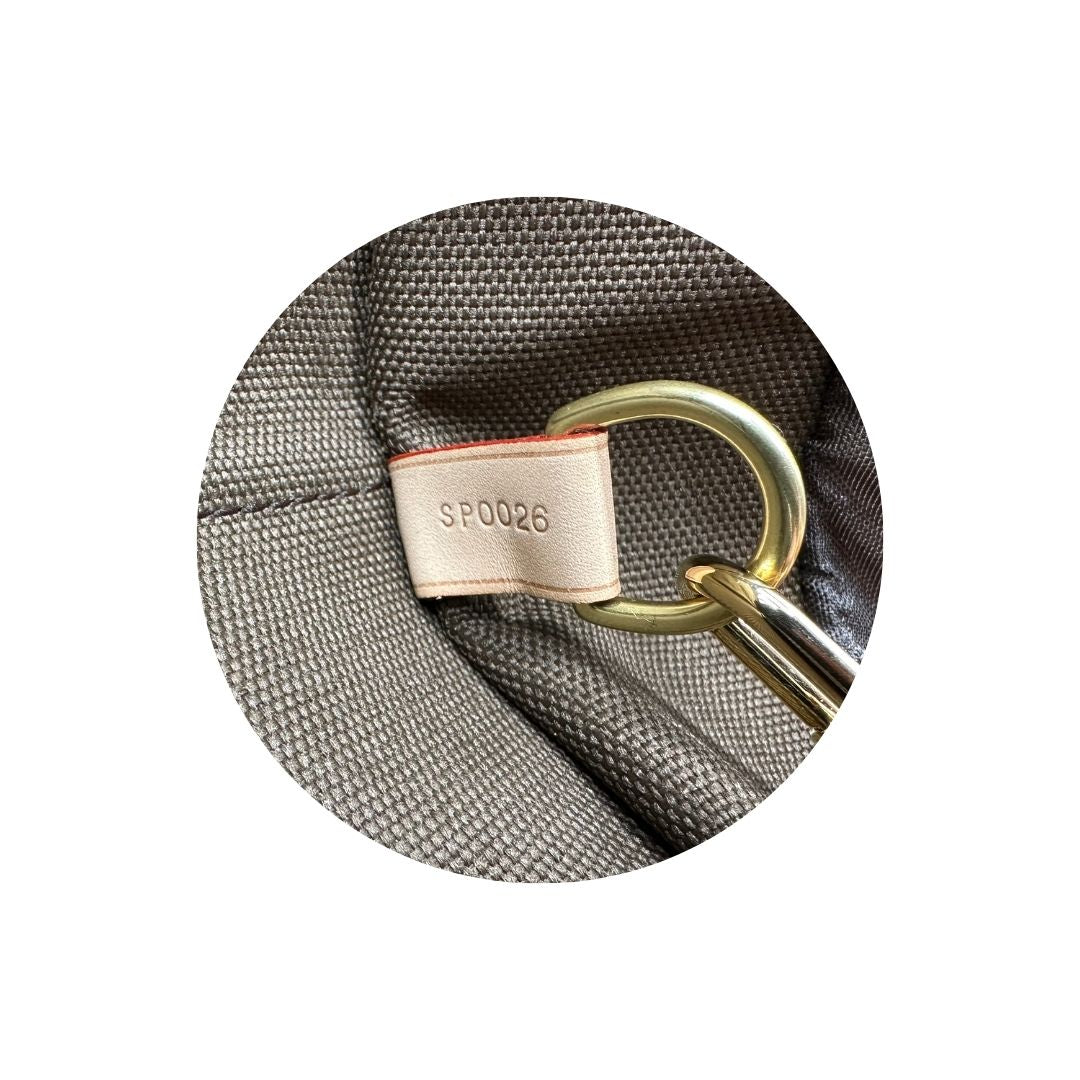 Codice di una Borsa da viaggio porta abiti in canvas marrone monogram con finiture in vacchetta naturale e parti metalliche dorate; munita di un manico singolo, una tracolla amovibile e regolabile e 2 grucce. Completa di Lucchetti e una chiave, dustbag.