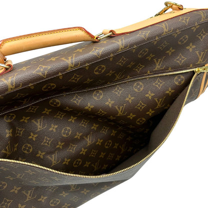 Borsa da viaggio porta abiti in canvas marrone monogram con finiture in vacchetta naturale e parti metalliche dorate; munita di un manico singolo, una tracolla amovibile e regolabile e 2 grucce. Completa di Lucchetti e una chiave, dustbag.