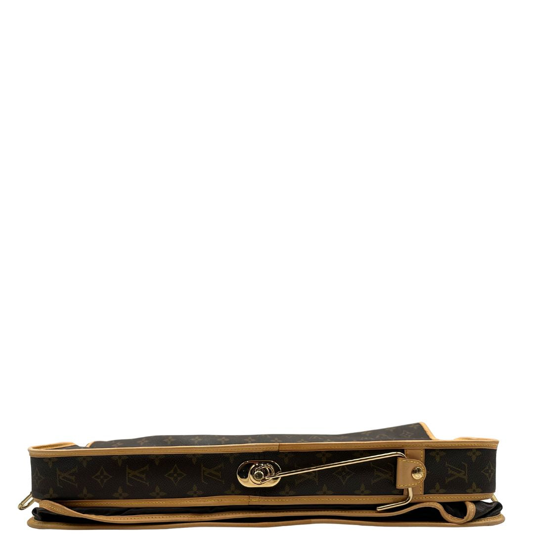 Base di una Borsa da viaggio porta abiti in canvas marrone monogram con finiture in vacchetta naturale e parti metalliche dorate; munita di un manico singolo, una tracolla amovibile e regolabile e 2 grucce. Completa di Lucchetti e una chiave, dustbag.