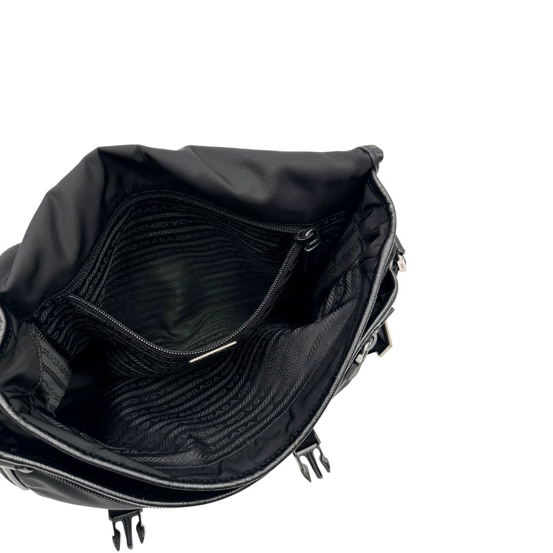 Interno di una Borsa Prada in nylon nero con finiture in pelle tono su tono e parti metalliche argentate; munita di una tracolla regolabile in tessuto. Originale, usata, di lusso, in ottime condizioni.