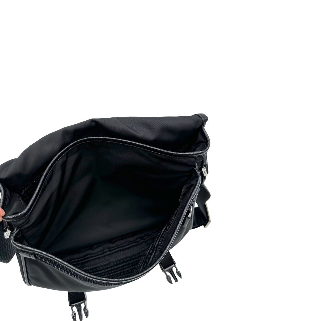 Interno di una Borsa Prada in nylon nero con finiture in pelle tono su tono e parti metalliche argentate; munita di una tracolla regolabile in tessuto. Originale, usata, di lusso, in ottime condizioni.