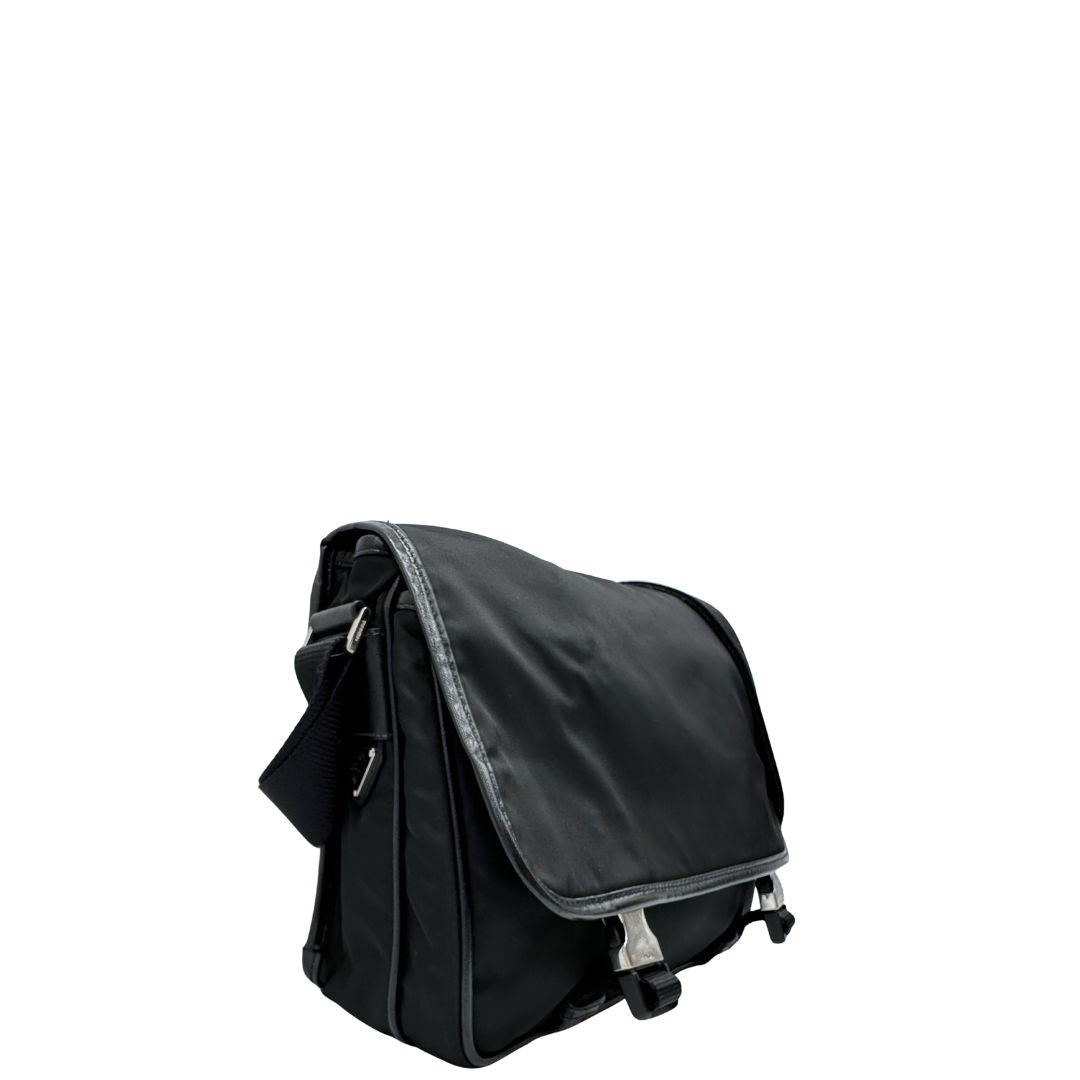 Lato destro di una Borsa Prada in nylon nero con finiture in pelle tono su tono e parti metalliche argentate; munita di una tracolla regolabile in tessuto. Originale, usata, di lusso, in ottime condizioni.