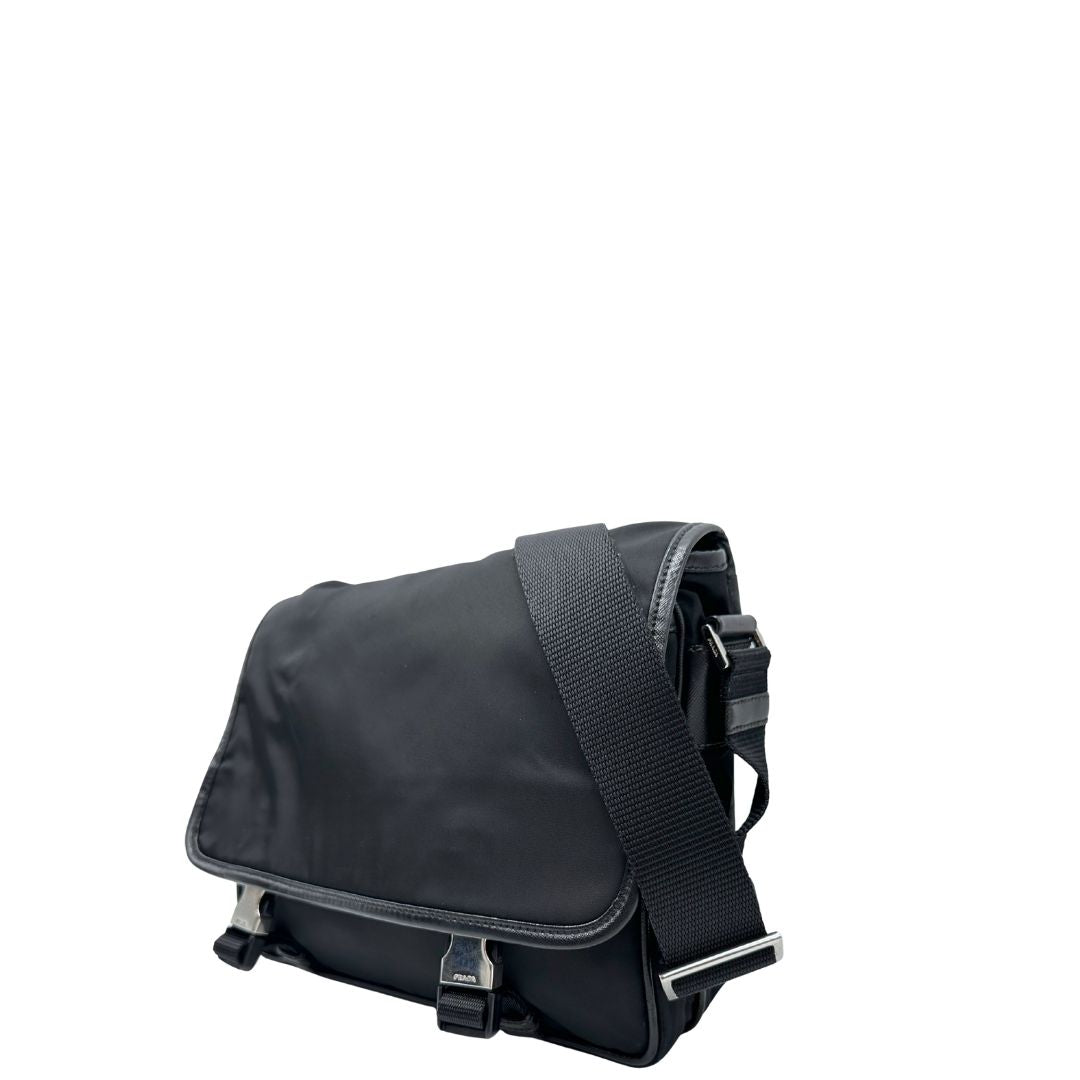 Lato sinistro di una Borsa Prada in nylon nero con finiture in pelle tono su tono e parti metalliche argentate; munita di una tracolla regolabile in tessuto. Originale, usata, di lusso, in ottime condizioni.
