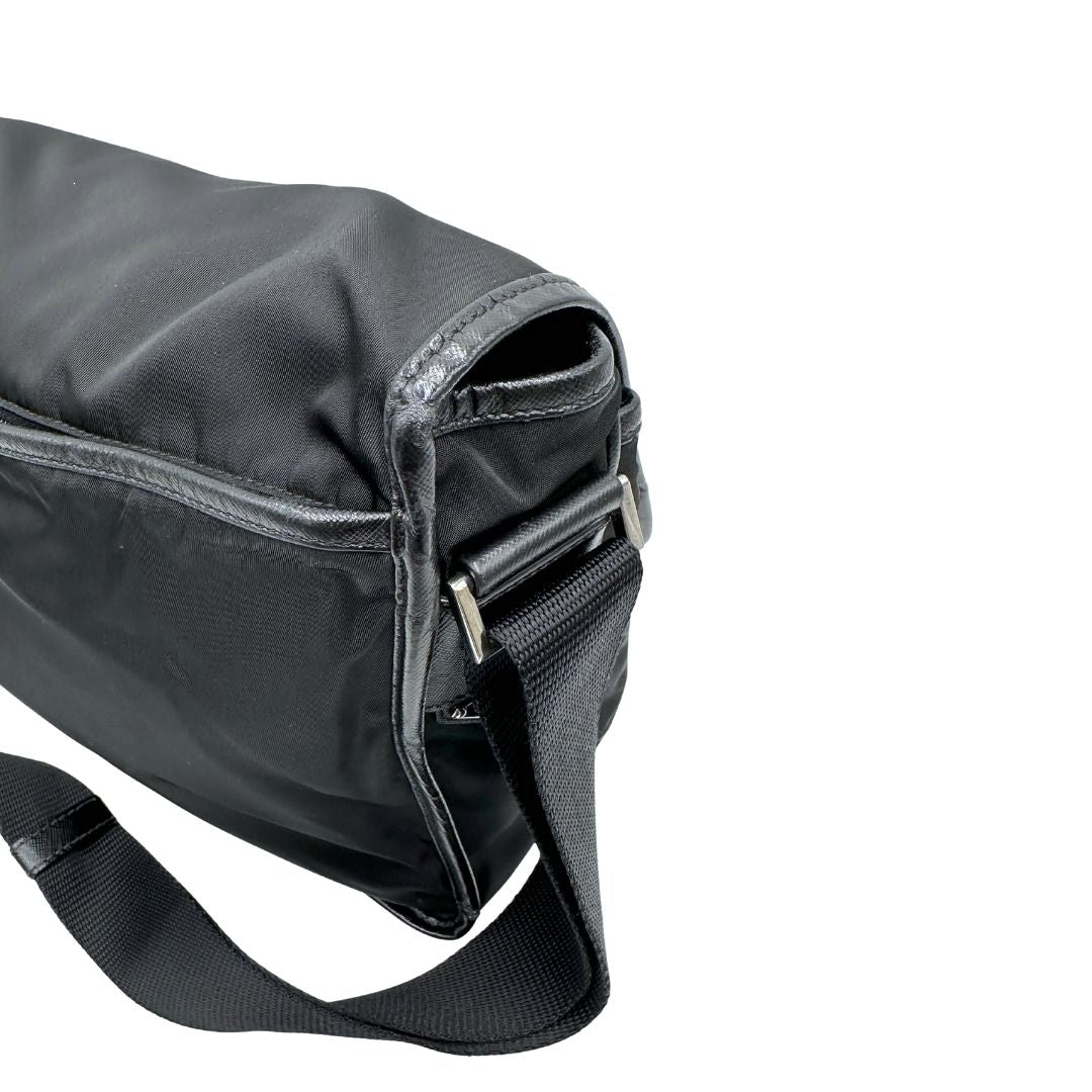 Lato superiore di Borsa Prada in nylon nero con finiture in pelle tono su tono e parti metalliche argentate; munita di una tracolla regolabile in tessuto. Originale, usata, di lusso, in ottime condizioni.