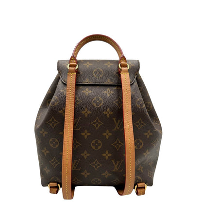 Retro di uno zaino Montsouris NM in canvas marrone monogram con finiture in vacchetta naturale e parti metalliche dorate, munito di un manico sulla parte superiore e due bretelle in vacchetta regolabili. Completo di corredo e charm decorativo.