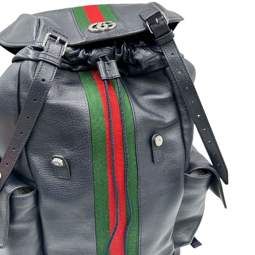 Apertura di uno zaino Gucci in canvas pelle blu notte, con parti metalliche argentate. Iconica striscia Web in verde/rosso sul front, con cinghie regolabili e tasche laterali. Completo di dustbag.