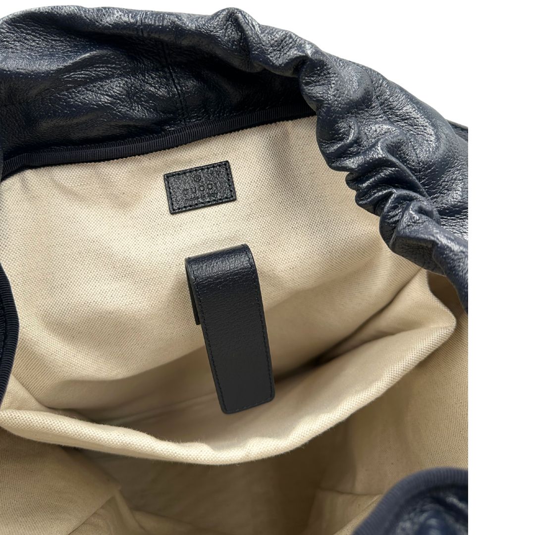 Interno di uno zaino Gucci in canvas pelle blu notte, con parti metalliche argentate. Iconica striscia Web in verde/rosso sul front, con cinghie regolabili e tasche laterali. Completo di dustbag.