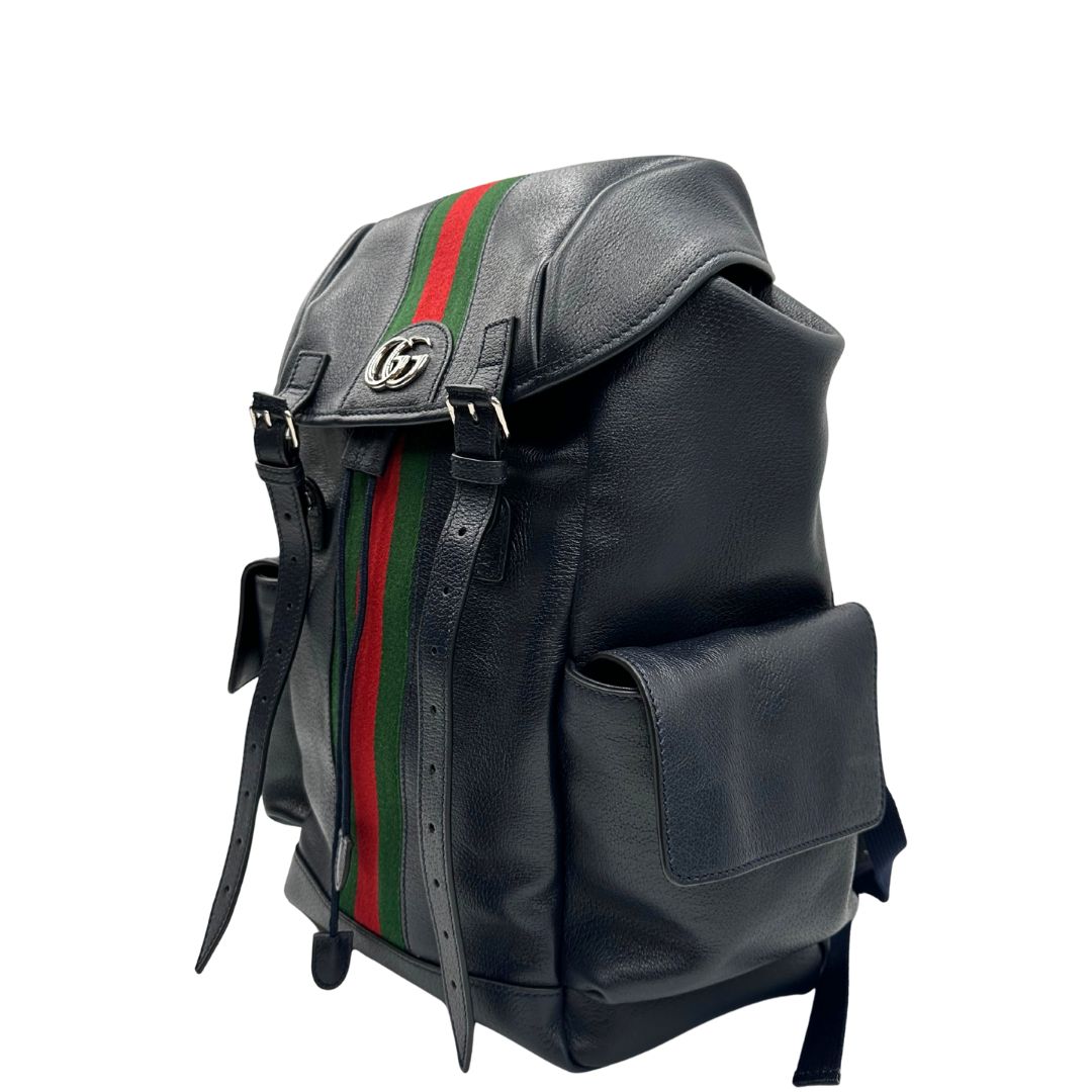 Laterale destro di uno zaino Gucci in canvas pelle blu notte, con parti metalliche argentate. Iconica striscia Web in verde/rosso sul front, con cinghie regolabili e tasche laterali. Completo di dustbag.
