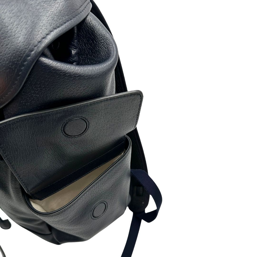 Tasche laterali di uno zaino Gucci in canvas pelle blu notte, con parti metalliche argentate. Iconica striscia Web in verde/rosso sul front, con cinghie regolabili. Completo di dustbag.