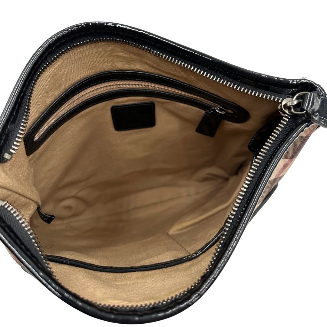 Interno di una Borsa Burberry in canvas beige tartan con finiture in pelle nera lucida e parti metalliche effetto renio. Munita di una tracolla fissa regolabile con fibbia. Completa di dustbag. Originale, usata, di lusso, in ottime condizioni.