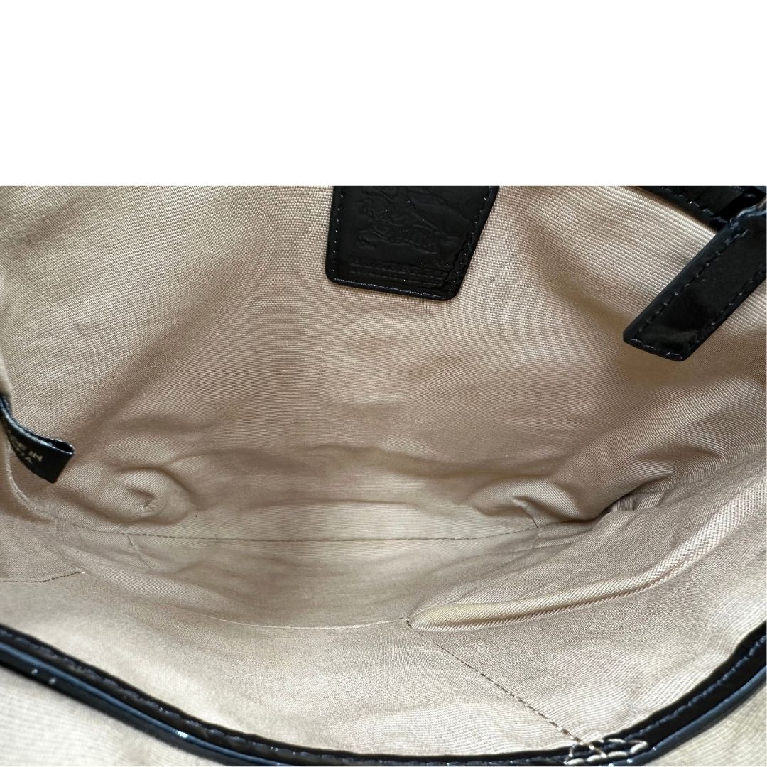 Interno di una Borsa Burberry in canvas beige tartan con finiture in pelle nera lucida e parti metalliche effetto renio. Munita di una tracolla fissa regolabile con fibbia. Completa di dustbag. Originale, usata, di lusso, in ottime condizioni.