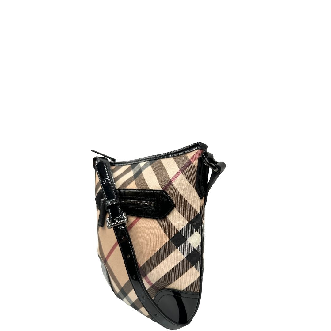 Lato sinistro di una Borsa Burberry in canvas beige tartan con finiture in pelle nera lucida e parti metalliche effetto renio. Munita di una tracolla fissa regolabile con fibbia. Completa di dustbag. Originale, usata, di lusso, in ottime condizioni.