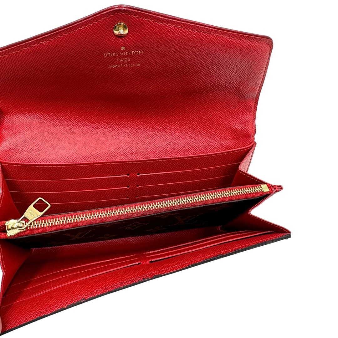 Portafoglio Louis Vuitton Sarah Retiro in canvas monogrammato marrone e finiture rosse, completo di corredo.