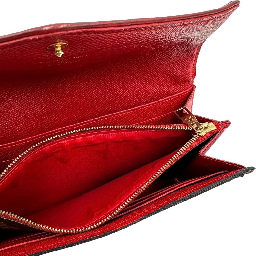 Portafoglio Louis Vuitton Sarah Retiro in canvas monogrammato marrone e finiture rosse, completo di corredo.