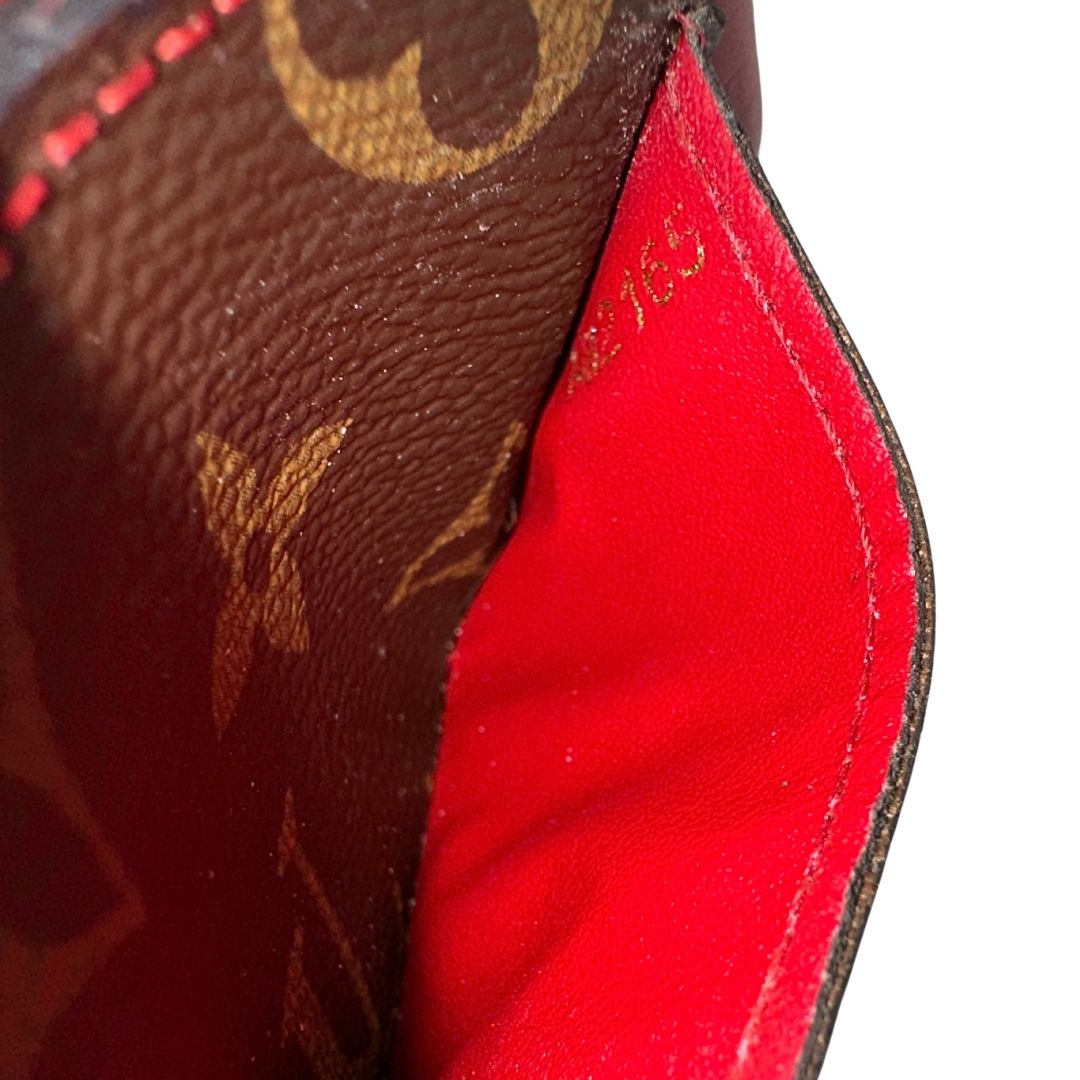 Portafoglio Louis Vuitton Sarah Retiro in canvas monogrammato marrone e finiture rosse, completo di corredo.