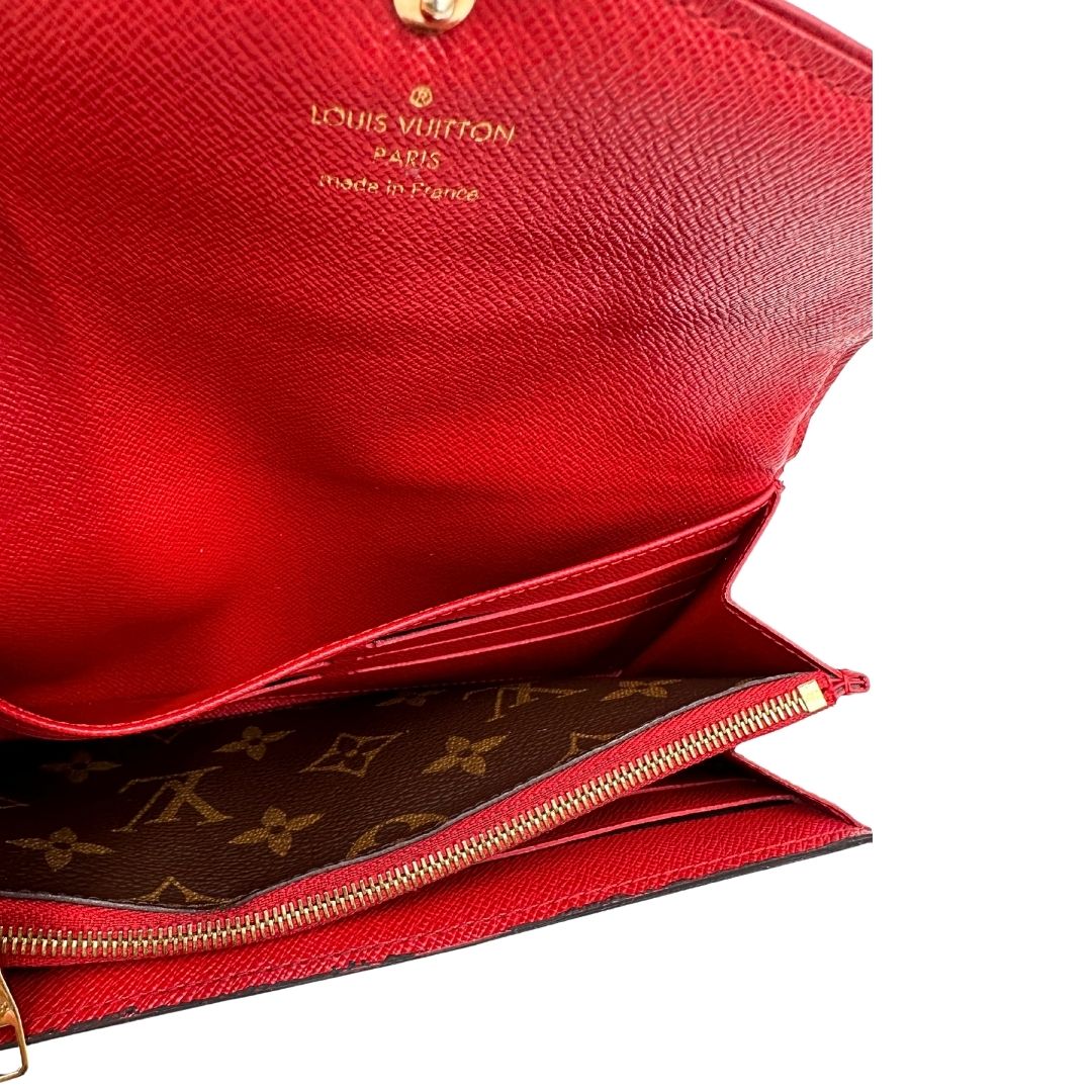 Portafoglio Louis Vuitton Sarah Retiro in canvas monogrammato marrone e finiture rosse, completo di corredo.