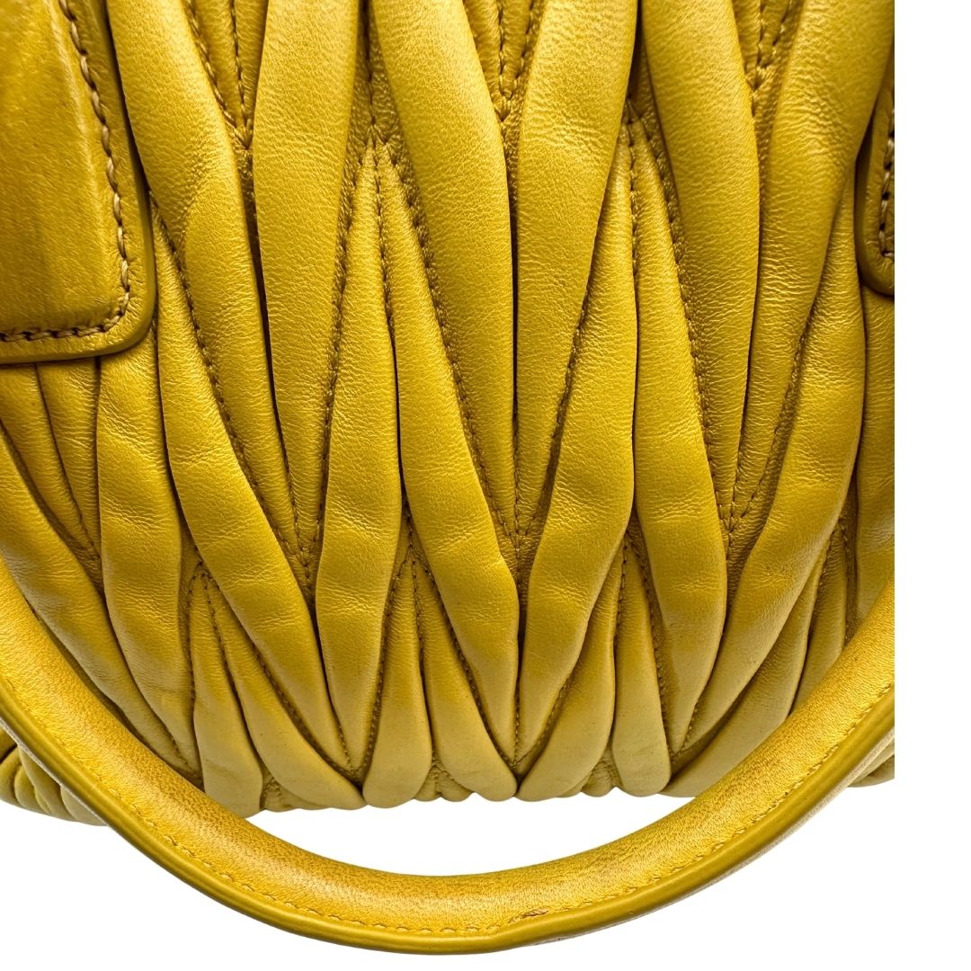 manici Borsa Miu Miu realizzata in pelle matelassè gialla con parti metalliche dorate; munita di doppi manici stondati e una tracolla amovibile e regolabile. Completa di dustbag, di lusso, originale, usata. 