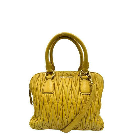 front Borsa Miu Miu realizzata in pelle matelassè gialla con parti metalliche dorate; munita di doppi manici stondati e una tracolla amovibile e regolabile. Completa di dustbag, di lusso, originale, usata.