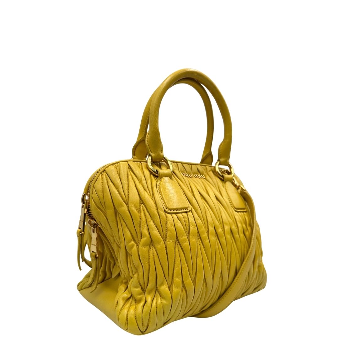 lato Borsa Miu Miu realizzata in pelle matelassè gialla con parti metalliche dorate; munita di doppi manici stondati e una tracolla amovibile e regolabile. Completa di dustbag, di lusso, originale, usata. 