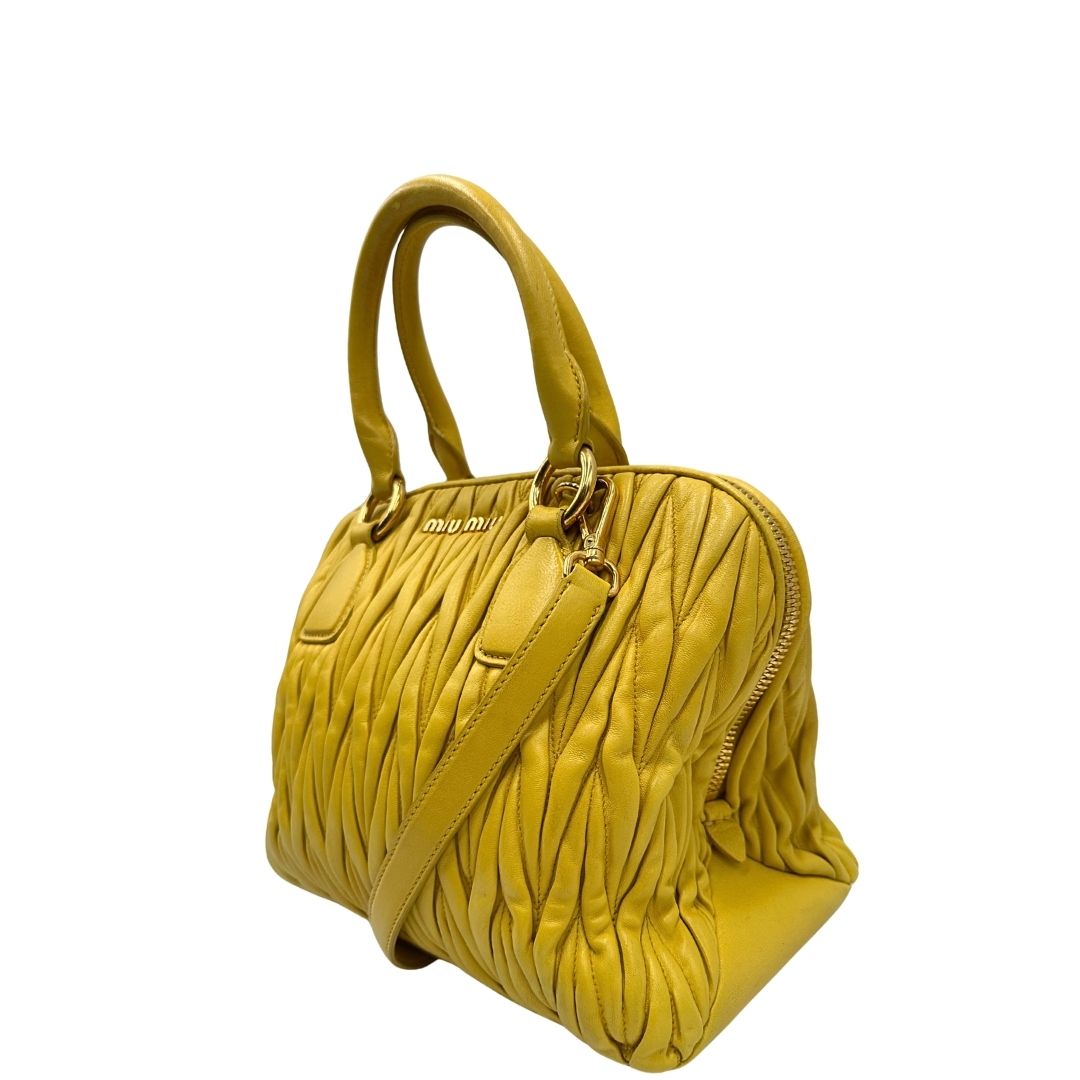 lato Borsa Miu Miu realizzata in pelle matelassè gialla con parti metalliche dorate; munita di doppi manici stondati e una tracolla amovibile e regolabile. Completa di dustbag, di lusso, originale, usata. 