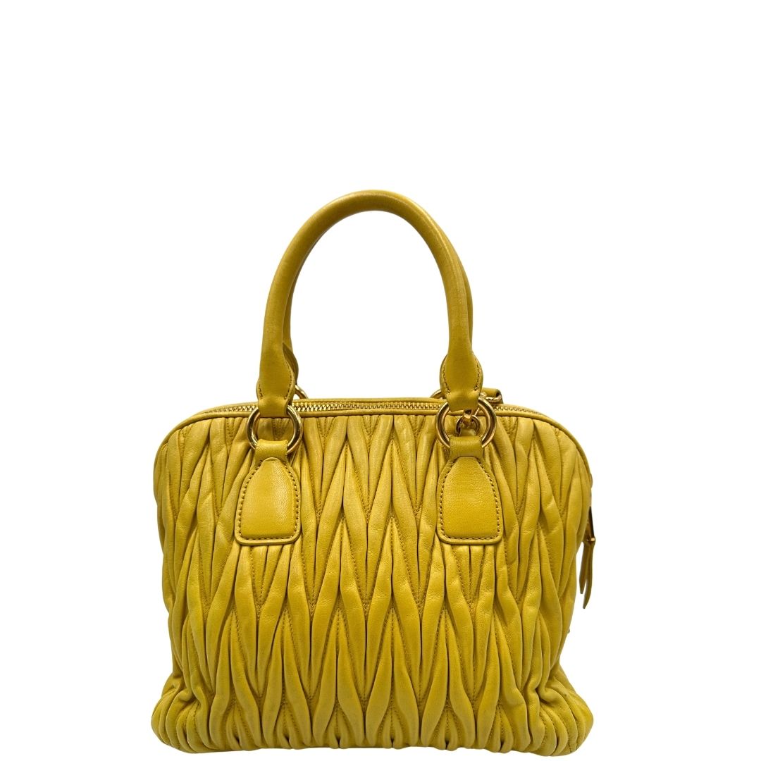 retro Borsa Miu Miu realizzata in pelle matelassè gialla con parti metalliche dorate; munita di doppi manici stondati e una tracolla amovibile e regolabile. Completa di dustbag, di lusso, originale, usata. 
