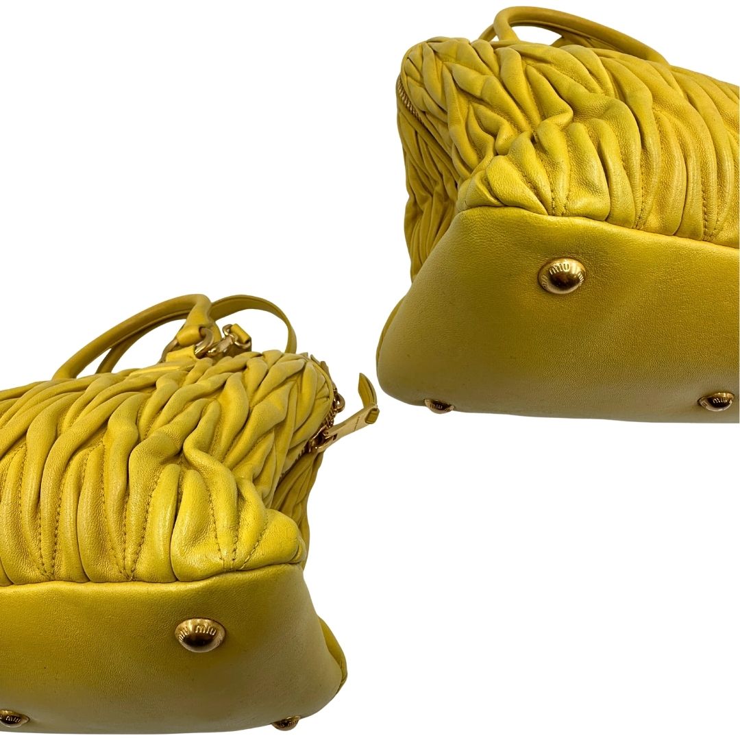 angoli Borsa Miu Miu realizzata in pelle matelassè gialla con parti metalliche dorate; munita di doppi manici stondati e una tracolla amovibile e regolabile. Completa di dustbag, di lusso, originale, usata.