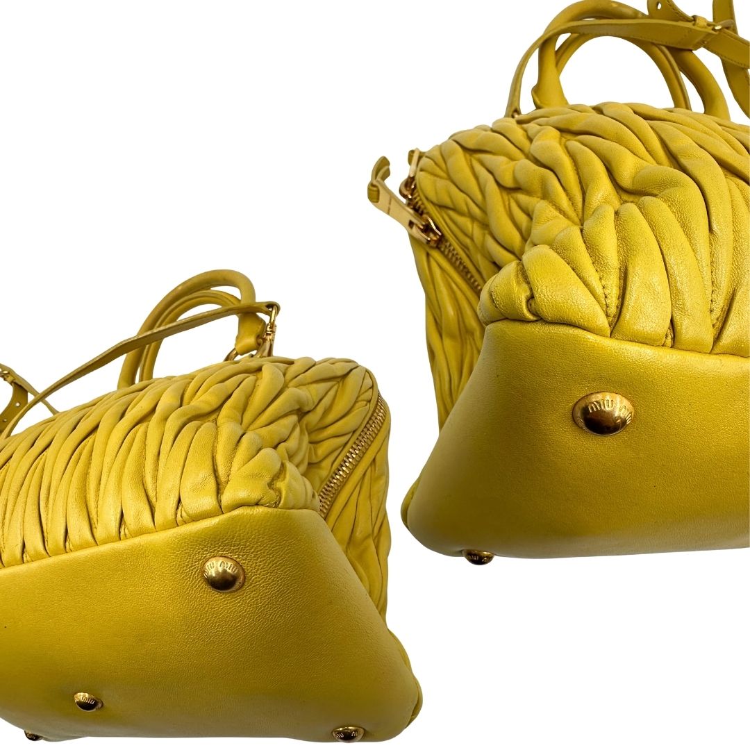 angoli Borsa Miu Miu realizzata in pelle matelassè gialla con parti metalliche dorate; munita di doppi manici stondati e una tracolla amovibile e regolabile. Completa di dustbag, di lusso, originale, usata. 