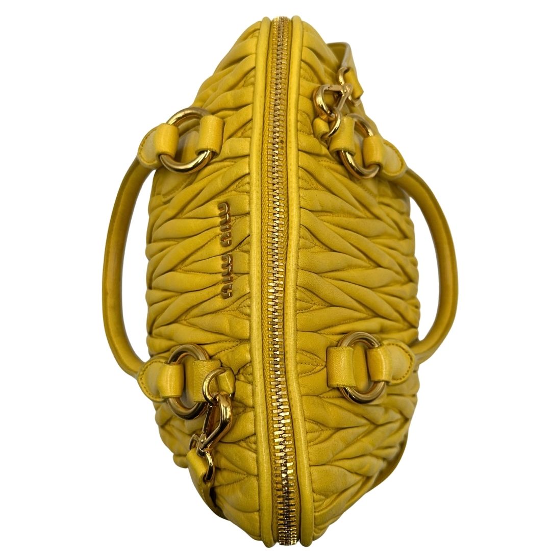 chiusura Borsa Miu Miu realizzata in pelle matelassè gialla con parti metalliche dorate; munita di doppi manici stondati e una tracolla amovibile e regolabile. Completa di dustbag, di lusso, originale, usata. 