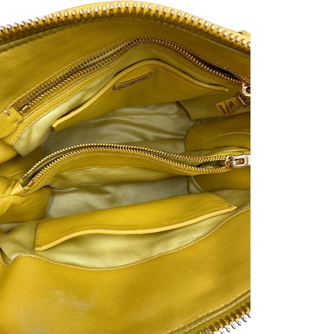 interno Borsa Miu Miu realizzata in pelle matelassè gialla con parti metalliche dorate; munita di doppi manici stondati e una tracolla amovibile e regolabile. Completa di dustbag, di lusso, originale, usata. 