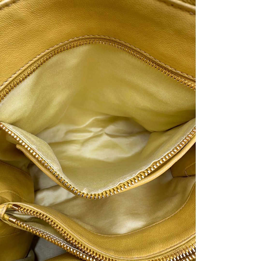 interno Borsa Miu Miu realizzata in pelle matelassè gialla con parti metalliche dorate; munita di doppi manici stondati e una tracolla amovibile e regolabile. Completa di dustbag, di lusso, originale, usata. 
