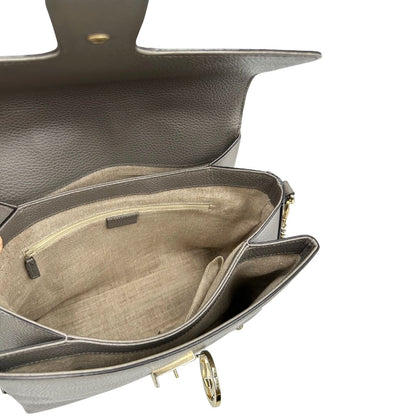 interno Borsa Gucci in pelle grigia martellata con parti metalliche dorate; impreziosita da doppia G sulla chiusura e munita di una tracolla in catena con spallaccio in pelle. Full set, di lusso, originale, ottime condizioni, usata. 