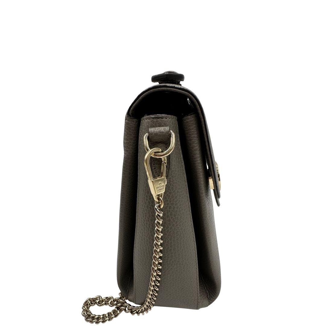 Borsa Gucci in pelle grigia martellata con parti metalliche dorate; impreziosita da doppia G sulla chiusura e munita di una tracolla in catena con spallaccio in pelle. Full set, di lusso, originale, ottime condizioni, usata.