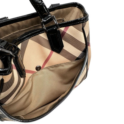 Interno di una borsa Burberry in canvas beige tartan con finiture in pelle nera lucida e parti metalliche effetto renio. Munita di doppi manici stondati. Completa di dustbag.