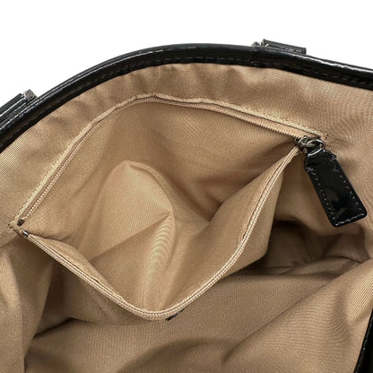 Interno di una borsa Burberry in canvas beige tartan con finiture in pelle nera lucida e parti metalliche effetto renio. Munita di doppi manici stondati. Completa di dustbag.