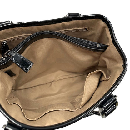 Interno di una borsa Burberry in canvas beige tartan con finiture in pelle nera lucida e parti metalliche effetto renio. Munita di doppi manici stondati. Completa di dustbag.