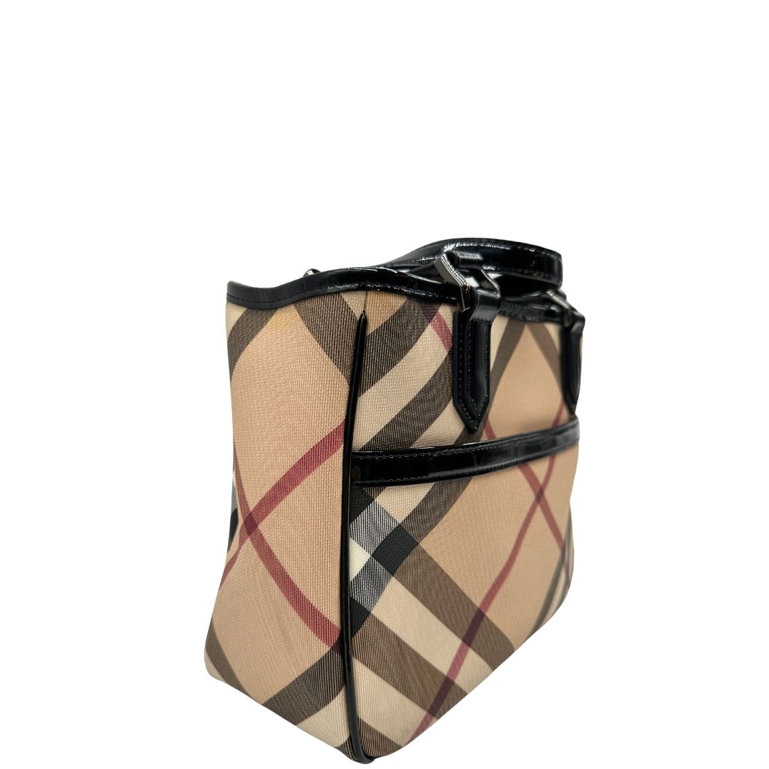 Laterale sinistro di una borsa Burberry in canvas beige tartan con finiture in pelle nera lucida e parti metalliche effetto renio. Munita di doppi manici stondati. Completa di dustbag.