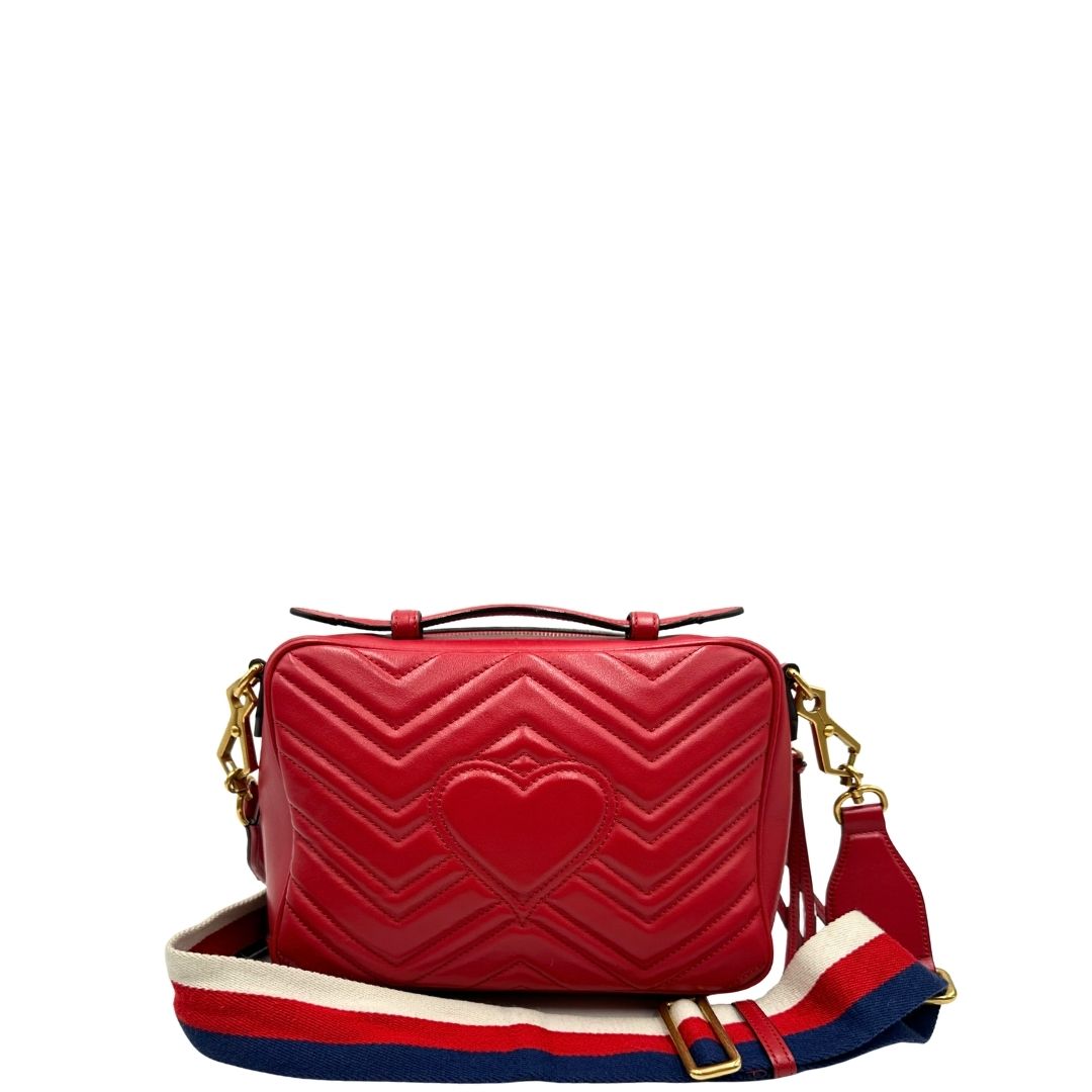 Retro di una borsa Gucci Marmont in pelle matelassè rossa e parti metalliche dorate; munita di un manico superiore e di una tracolla in tessuto web blu/bianco/rosso, regolabile ed amovibile. Indossabile a mano o a tracolla. Completa di dustbag.