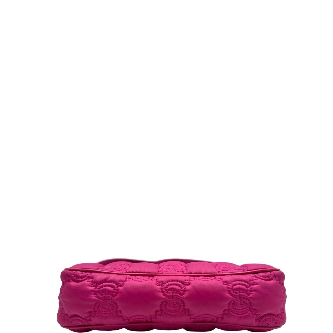 Base di una borsa Gucci in nylon trapuntato matelassé fucsia con trama GG, finiture in pelle tono su tono, manico singolo in catena e tracolla in tessuto regolabile ed amovibile. Rifinita con parti metalliche argentate. Completa di dustbag.